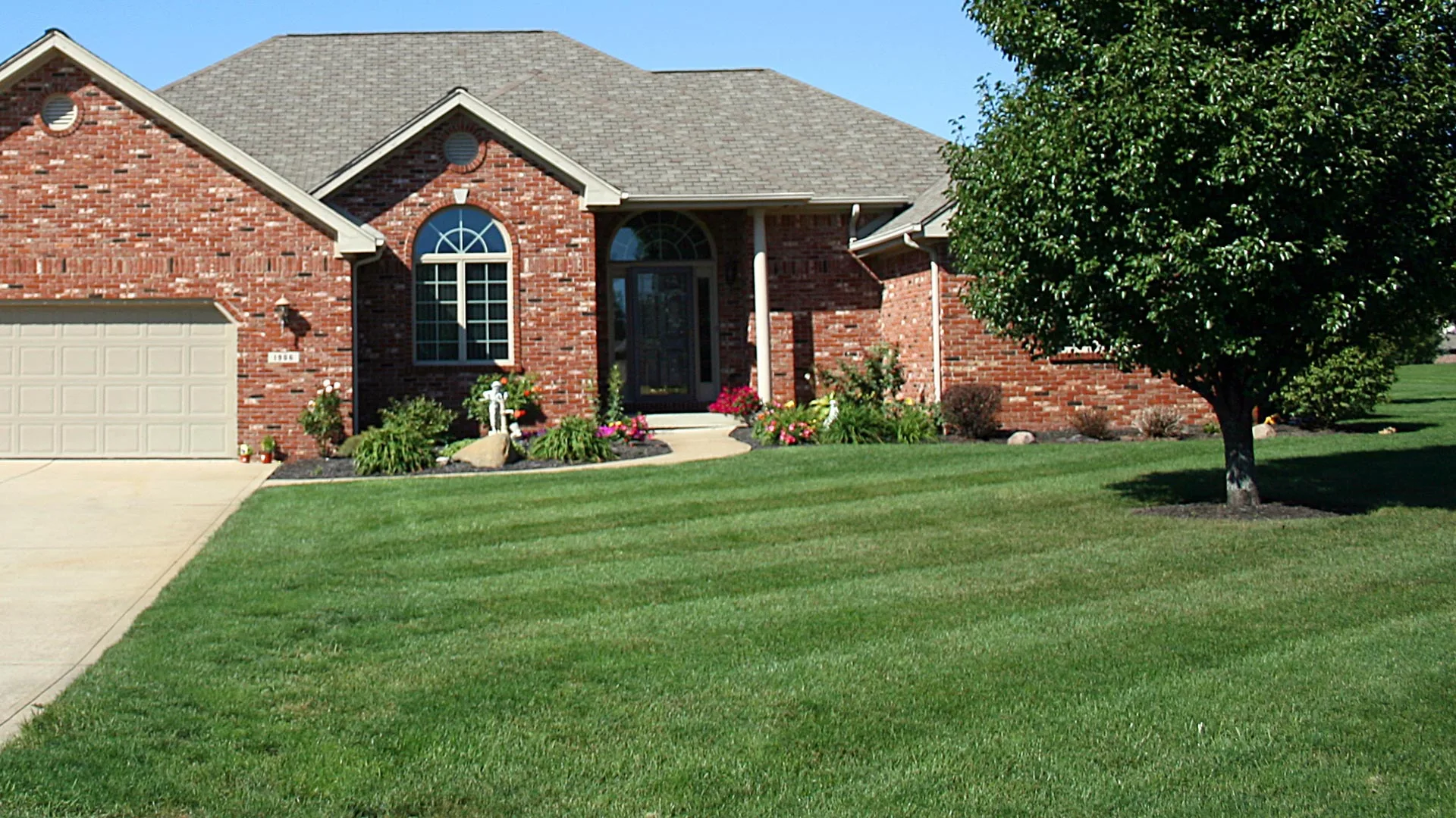 A professionally maintained lawn and landscape at a home in Des Moines, IA.