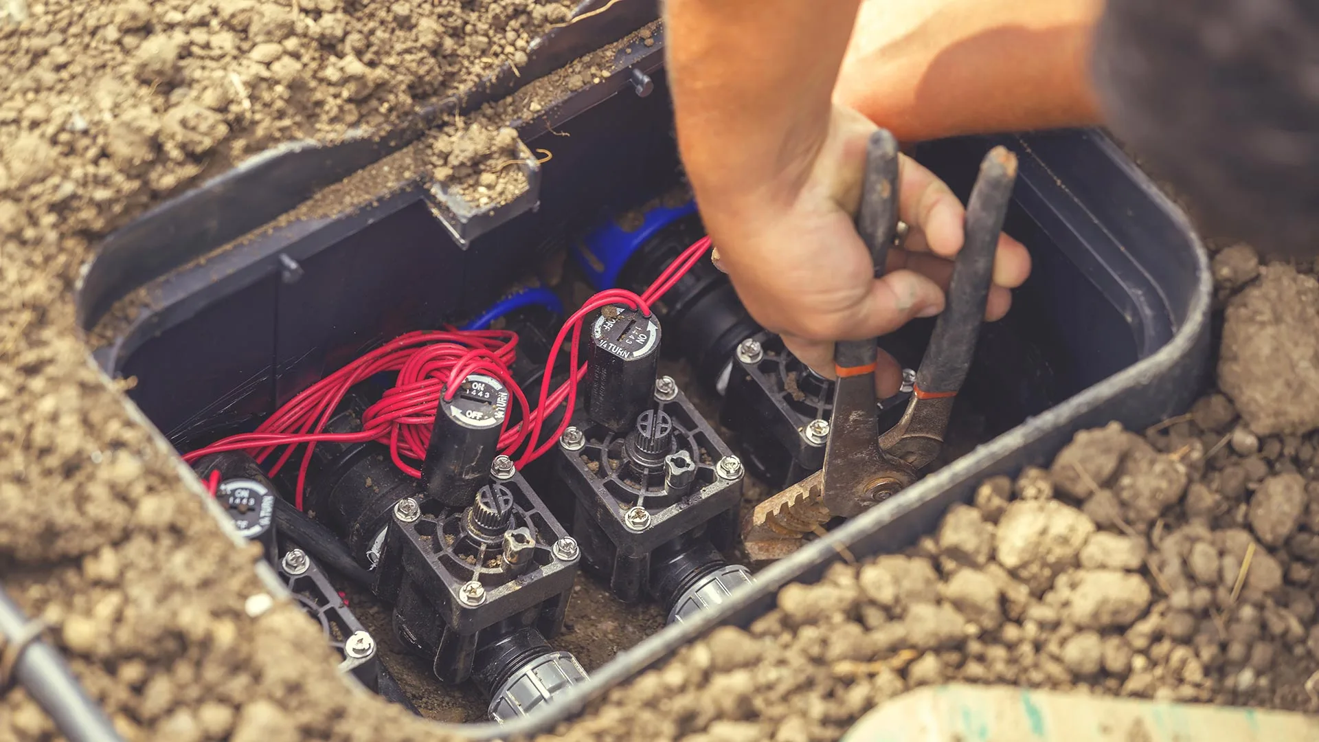An employee tweaking irrigation valves for a customer in Des Moines, IA.