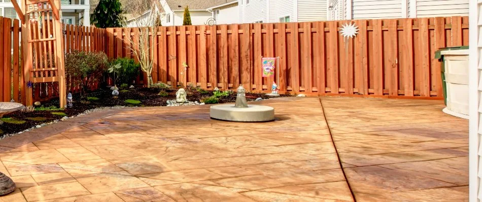 Fenced yard in Des Moines, IA, with stained concrete patio.