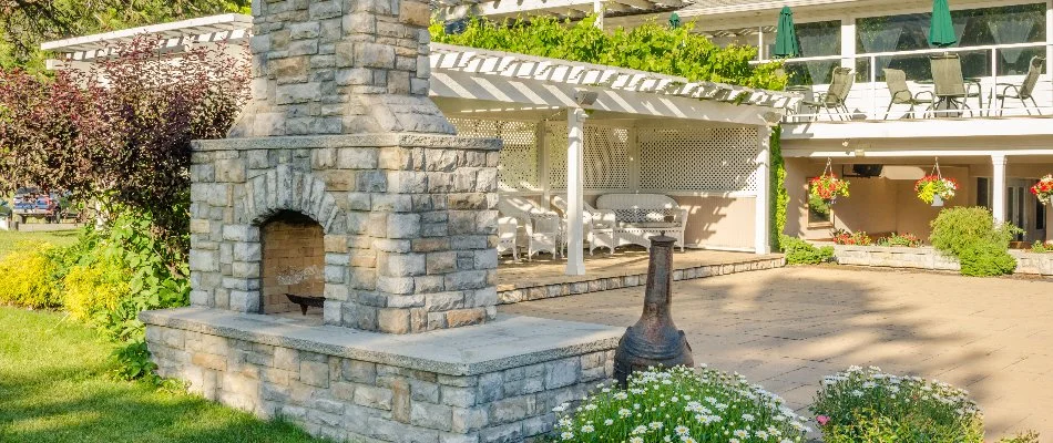 Outdoor fireplace in a backyard in Des Moines, IA, with a lounge area.