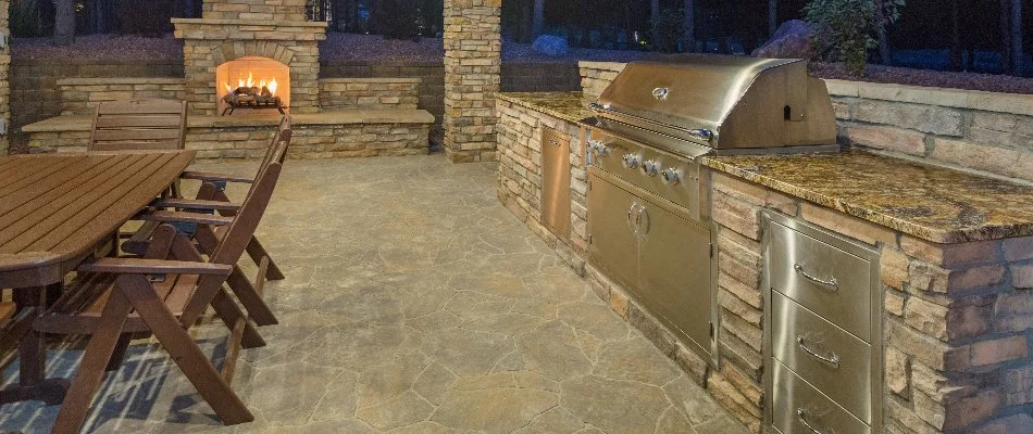 Outdoor kitchen in Des Moines, IA, with a grill and fireplace.