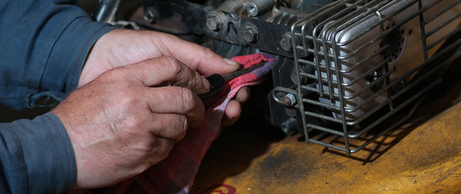An employee doing maintenance on a customer's lawn mower in West Des Moines, IA.