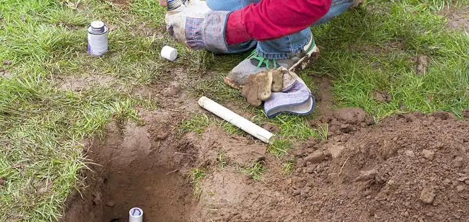 A+ Lawn & Landscape team member addressing a sprinkler system issue for a homeowner in West Des Moines
