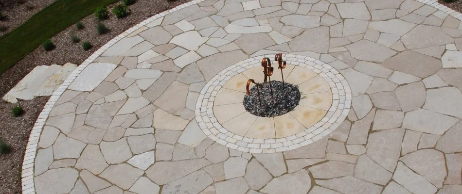 Circular flagstone patio with surrounding landscaping in Marquisville, IA.