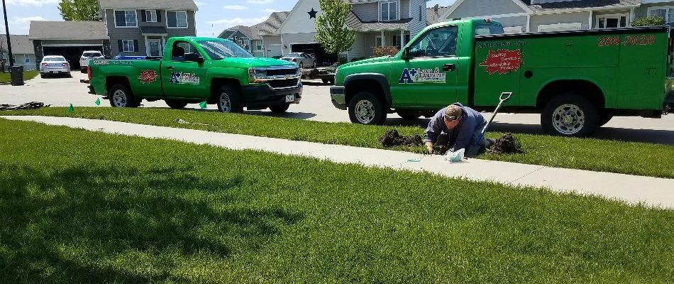 Worker repairing an irrigation system on a property in Lakewood, IA.