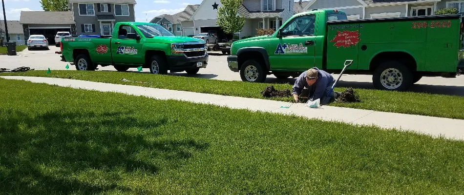 Tech repairing irrigation in Marquisville, IA, with company trucks.