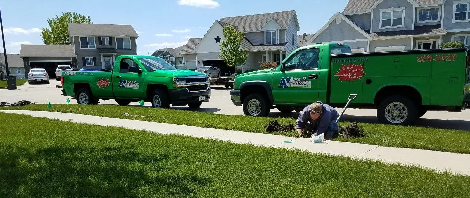 Worker performing an irrigation repair on a property in Fairmont Park, IA.